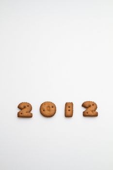 2012 number made by brown biscuits in lower center of white surface in portrait orientation for background use