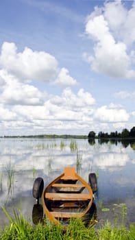 landscape with one wooden boat on summer lake