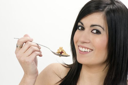 A horizontal composition of a woman eating cereal