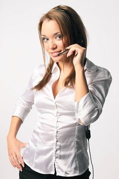 The young and beautiful girl from a support service with ear-phones and a microphone on a head