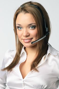 The young and beautiful girl from a support service with ear-phones and a microphone on a head
