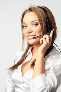 The young and beautiful girl from a support service with ear-phones and a microphone on a head