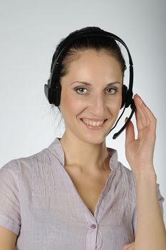 The young and beautiful girl from a support service with ear-phones and a microphone on a head