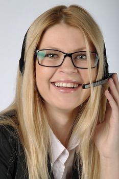 The young and beautiful girl from a support service with ear-phones and a microphone on a head