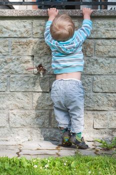 Baby boy in grey and blue making pull-ups