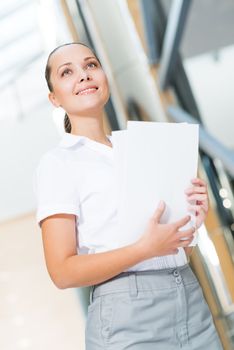 Portrait of a successful business woman in the office, holding papers and smile