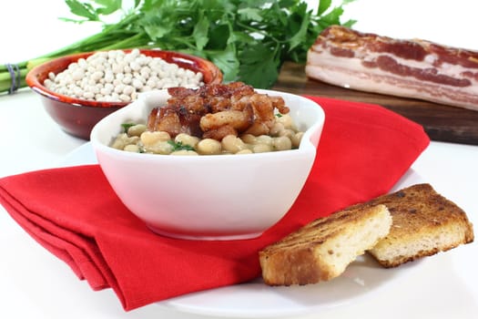 a bowl of white beans and fried bacon