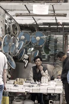 HONG KONG - 17 DEC, A Chinese hawker is selling electric appliances and other accessories in Ap Liu Street, Hong Kong on 17 December, 2011. It is one of the famous street in Hong Kong.