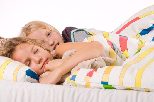 Two young children enjoying their colorful bed