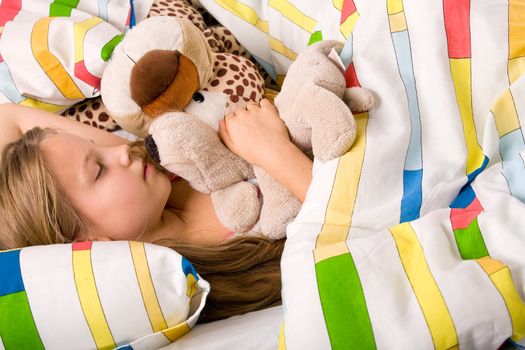 Sleeping young cute child in a colorful bed