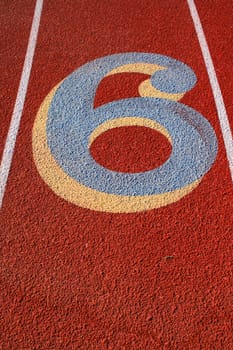 Close up of a number six on a running lane.
