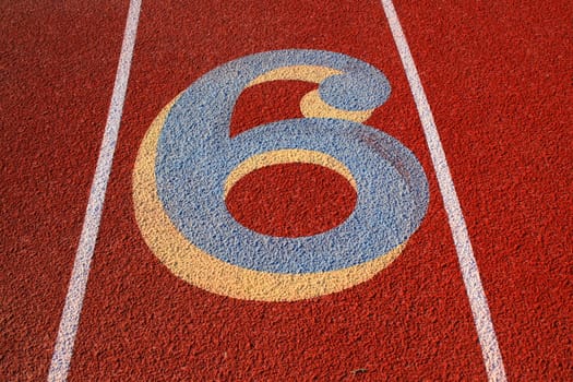 Close up of a number six on a running lane.
