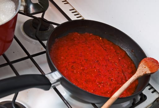 Pan on stove full of tomato sauce