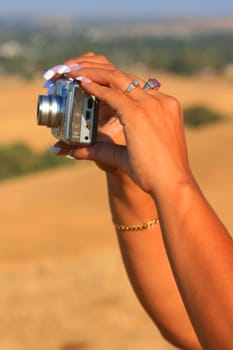 Close up of woman's hands holding digital camera.
