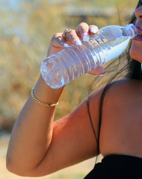 Close up of a woman drinking water.
