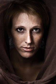 Studio portrait of a cute and beautifull girl in a turtle neck sweater looking at you