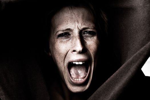 Studio portrait of a cute and beautifull girl in a turtle neck sweater screaming