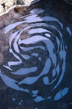 an impression of a face in the water of a coastal pool