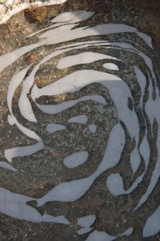 an impression of a face in the water of a coastal pool