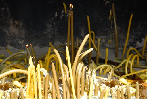 Burned candles in the sand outside the church