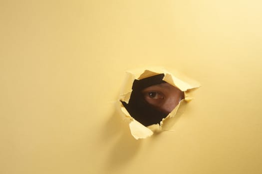 stock image of thief peeping through a hole