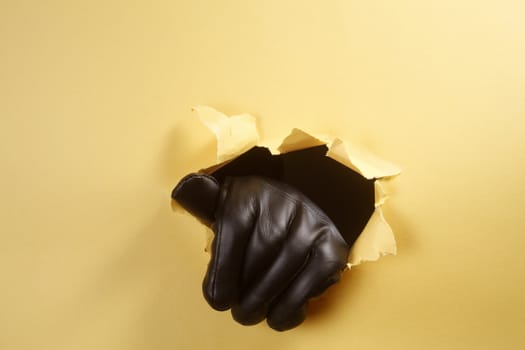 hand wiith leather glove breaking through the hole