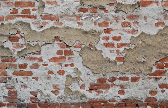 Old town house brick wall with destroyed parget