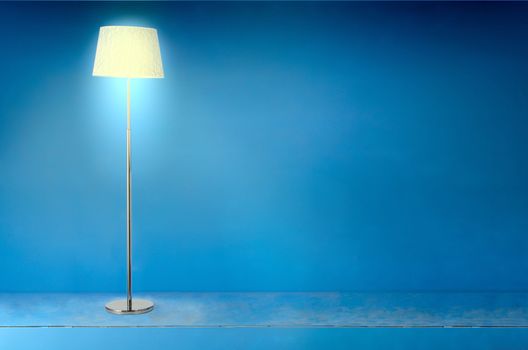 Lit floor vintage lamp over blue grunge background