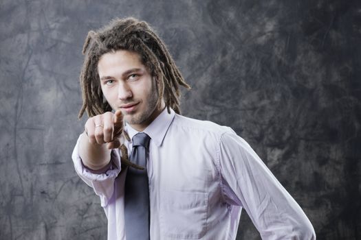 Young business man in suite, pointing at camera