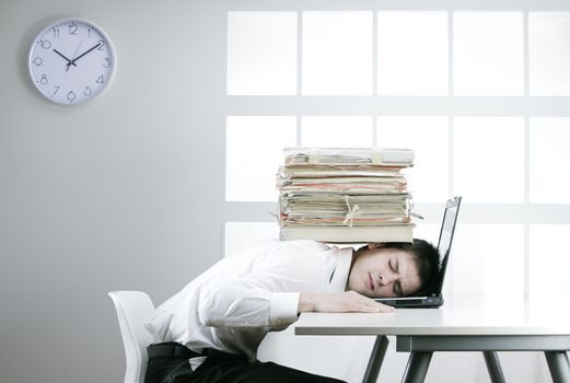 A stressed businessman with a stack of documents on his head