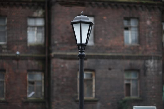 Lamppost on the background of an old brick building