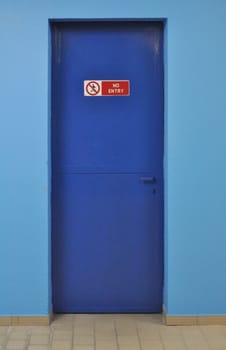 No entry sign on a blue firewall door