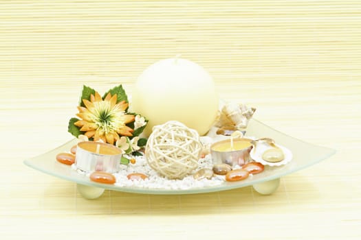 Home decoration with candle and artificial flower on decorative glass plate