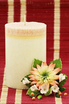 Multicolored candle arranged with beautifull flowers as a home and spa decoration