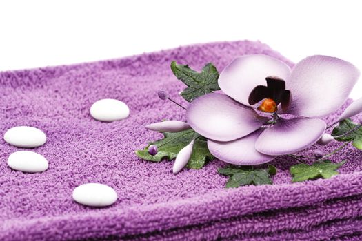 Purple towel and flower as a spa decoration isolated on white background