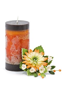 Multicolored candle arranged with beautifull flowers as a home and spa decoration