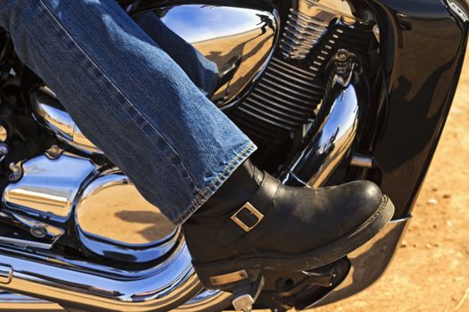 Biker boot with reflection on chrome cover and engine detail