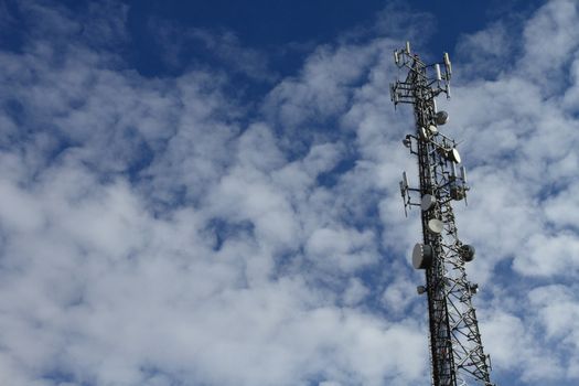 Large telecommunication tower with dramatic clouds in the sky