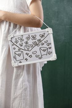 little girl holding a white board like hand bag