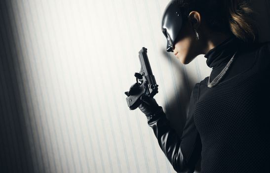 Female thief in black mask with gun