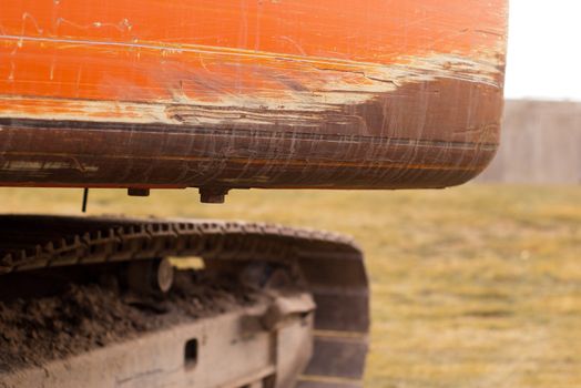 scratched back end of an orange trackhoe