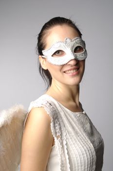 Young and beautiful girl in the mask and costume of an angel