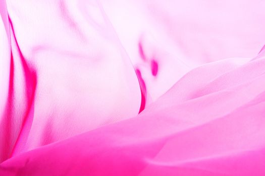 Pink fabric winds waves, creating a beautiful background of the folds