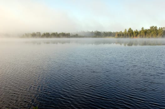 Fog above lake in the morning
