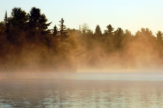 Sunrise and mist in beautiful lake in Algonquin Park