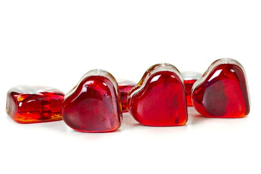 Red heart shaped gems on white background