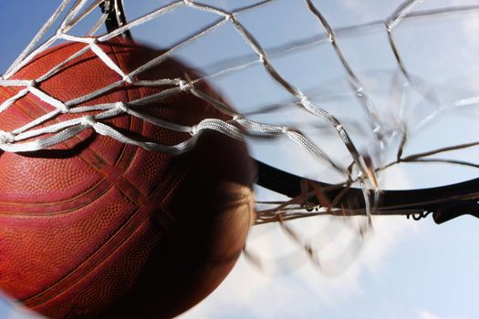 Picture of a basketball field goal with the sky in background.