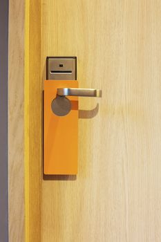 hotel door with orange card to avoid disturbing
