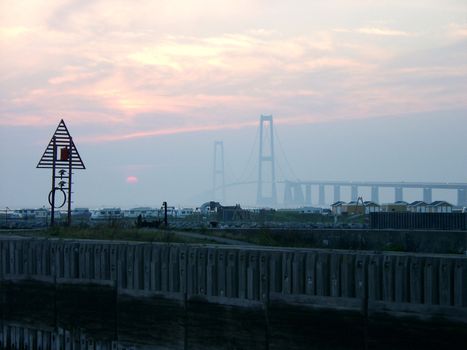 View of sunset over the camping near Storebelt Bridge in Denmark.