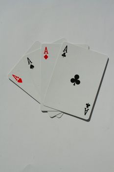 Close up of four aces on a white background.
